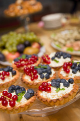 Top view on small cakes with vanilla cream and berries
