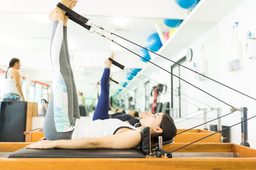 Fit Woman Exercising On Reformer Machine at a Gym
