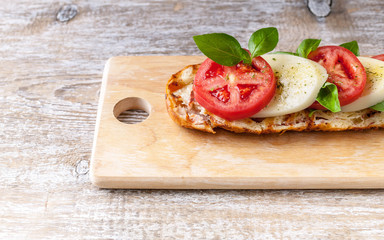 Fototapeta na wymiar Sandwich with tomatoes, mozzarella, basil leaves and spices. Close-Up