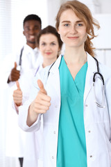 Fototapeta premium Medical team of confident doctors showing Ok sign with thumbs up. Medicine and health care, insurance concept