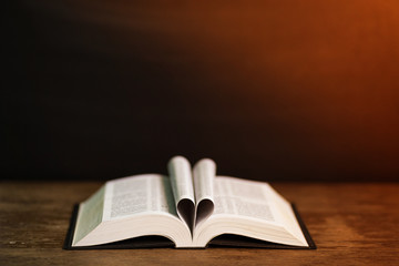 Book page in heart shape with dark background. Conceptual Heart from Book. Copy Space