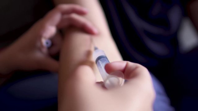 Injection from a syringe into a vein on the arm
