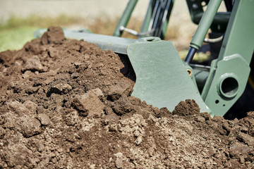 Tractor Bucket scooping up Dirt