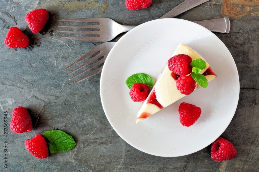 Aufkleber slice of raspberry cheesecake on a plate, top view scene over a dark background