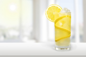Lemonade with fresh lemon on desk