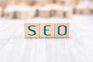 The Word SEO Formed By Wooden Blocks On A White Table