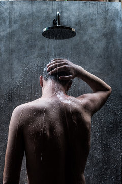 Handsome caucasian man taking a rain shower