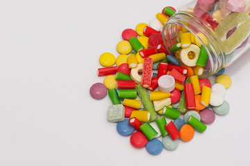 Colorful candy in a jar on a white background