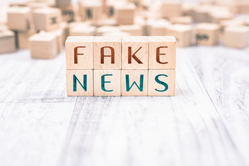 The Words Fake News Formed By Wooden Blocks On A White Table