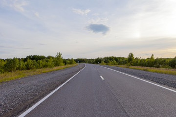 Fototapeta premium An empty road leading to the village on the hills.