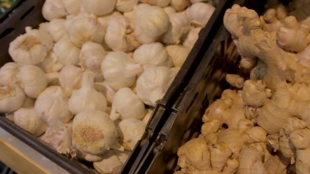 Camera pan of ginger and garlic displayed in a shop