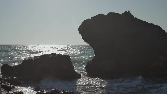 Waves crushing at the west coastline of Rhodes Island, Greece. Shot in slow motion at 96 frames/ second. There is a high contrast from the sun that colors the picture brightly.