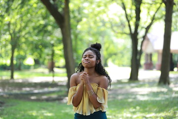 Faithful black woman worshipping in nature