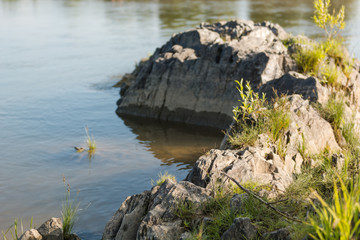 Fototapeta na wymiar A small lake with a stony shore in Russia