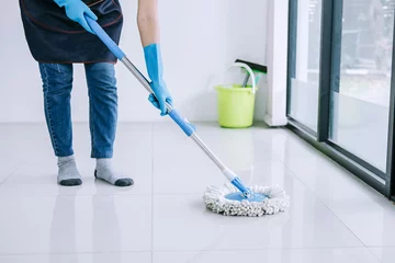 Fotobehang Housekeeping and cleaning concept, Happy young woman in blue rubber gloves wiping dust using mop while cleaning on floor at home © Freedomz