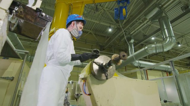 worker lubricates machine rotating shaft with engine lubrication in workshop