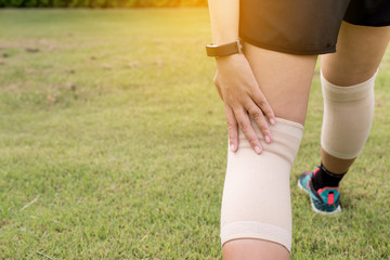Woman suffering from pain in leg injury after sport exercise running,Female using elastic bandage with her legs