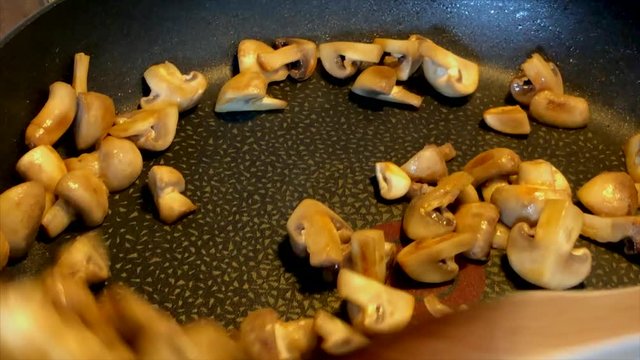 Cooking champinions in a frying pan