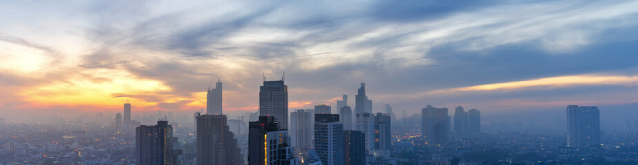 panorama of early morning cityscape with sunrise and high mist and cloudscape