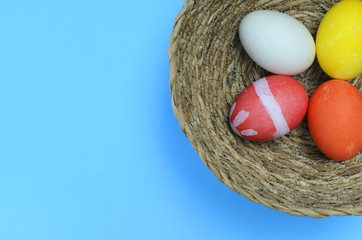 colorful easter eggs in basket on blue backgrounds above Top views