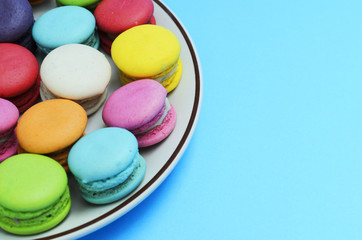 Fototapeta na wymiar Colorful of mini French macaroons cookie on blue backgrounds. Place for your text