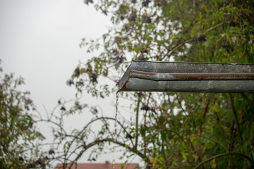 Water stream flowing from a gutter during rain