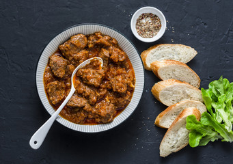 Delicious beef stew. Healthy seasonal comfort food on a dark background, top view. Flat lay, copy...