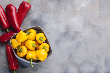 Sweet pepper is yellow and red, on a gray background. Free space for text, frame. Top view