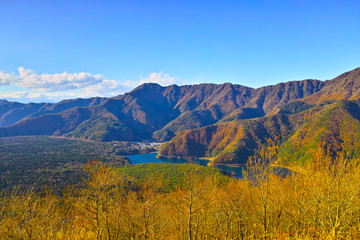 紅葉シーズンの三湖台から西日を受けた西湖と樹海の風景

