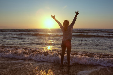 Fototapeta na wymiar Silhouette of a young girl on the beach.