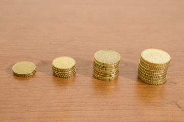 Many euro coins in stacks on a wood table