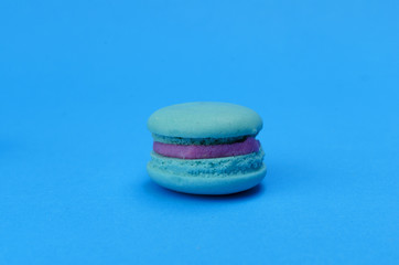 Single mini macaroon dessert food on blue pastel color ackgrounds