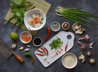 Asian food on a dark background, Wok rice with shrimps and mushrooms, During preparation