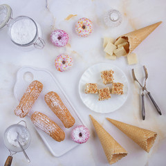 Eclairs and donuts with coffee on a marble background, Light background, Confectionery in a blogger style