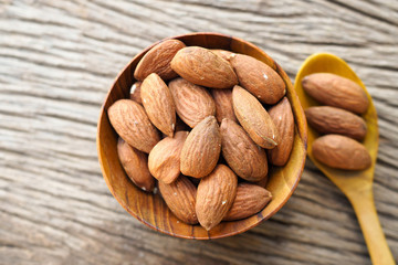 Almonds nuts in wood bowls on brown wooden table