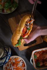 Vietnamese sandwich bread with meatballs in tomato sauce and radish, carrot pickle, cucumber,...
