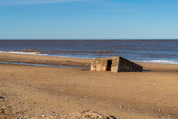 North sea coast in Caister-on-Sea, Norfolk, England, UK -  with an old bunker on the beach