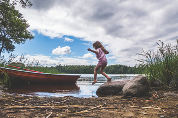  a child walks on the water, lake, river, near the boat in the woods