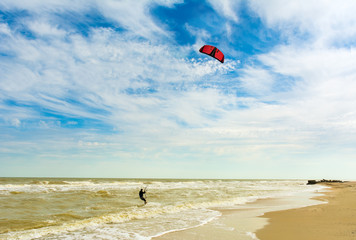 Obraz premium Kiteboarding. A kite surfer rides the waves. Holidays on nature. Artistic picture. Beauty world.