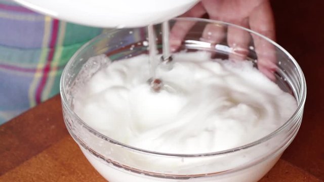 La cuoca in cucina monta l'albume per il dolce tiramis&ugrave;