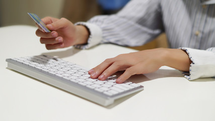 woman holding credit card over keyboard for shopping payment concept