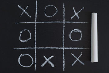 Fototapeta na wymiar O X Game on black chalk board
