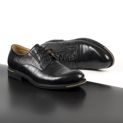 Classic male black leather shoes isolated on a white and black