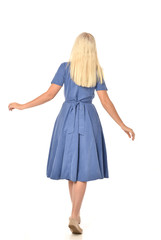 full length portrait of blonde girl wearing blue dress. standing pose with back to the camera. isolated on white  studio background.