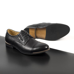 Pair of male shoes isolated on the white and black background
