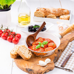 Baked mini meatballs in tomato sauce with basil