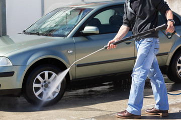 Car washing. Man cleaning car using high pressure water and brush outdoor