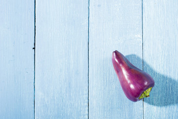 purple chili pepper on blue wooden table background