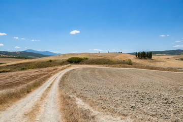 Tuscany holidays. Italy holidays tuscany. Summer landscape in Tuscany with fields, blue sky and road, Italy, Europe. Vacation in beautiful Italy.