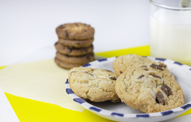 Milk and chocolate cookies on clean white yellow pop background